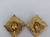 a pair of gold earrings with a lion head on the front