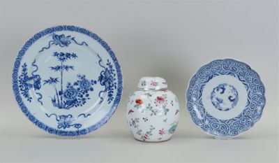 trois assiettes bleues et blanches et un petit vase posés sur une table
