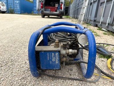 une machine bleue posée au sol à côté d'un camion