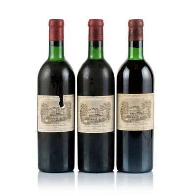 three bottles of red wine sit next to each other on a white surface