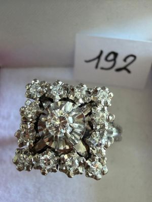 une photo d'une bague en diamant posée sur un tissu blanc
