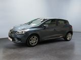 a grey car is parked in a room with a white wall