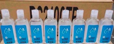 six bottles of water are lined up in a row in front of a cardboard box