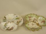 two porcelain dishes with floral designs on them sitting on a table