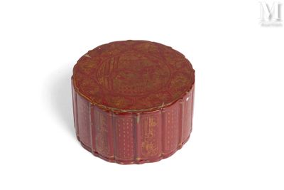 une petite boîte rouge avec un couvercle, posée sur une surface blanche