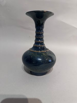 a blue vase that is sitting on a white table