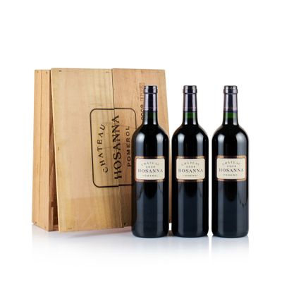 trois bouteilles de vin devant une caisse en bois