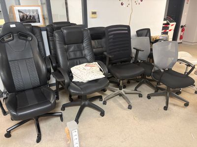 several black office chairs are lined up in a circle in a room