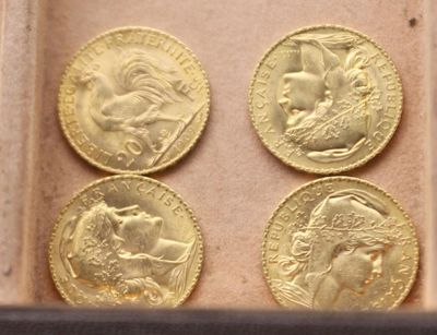 quatre souverains d'or dans une boîte posée sur une surface blanche