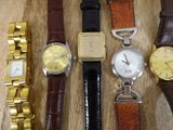 four different types of watches on a wooden table