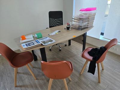 deux chaises et une table dans une pièce où il y a beaucoup de papiers sur la table