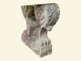 a stone sculpture of a head on a pedestal