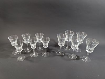 six verres à vin transparents sont alignés sur une surface noire