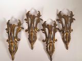 trois appliques dorées sur un mur blanc, avec un fond blanc