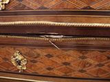 a close up of a chest of drawers with a bird on it