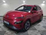 une voiture rouge est garée dans une pièce au sol en damier