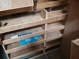 a wooden cabinet with drawers in the corner of the room