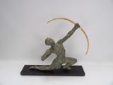 statue of a man with a scythe in his hand on a black base