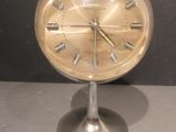 une horloge posée sur un support sur une table