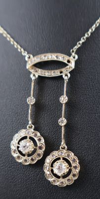 a close up of a necklace and earrings on a black surface