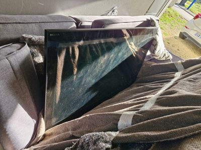 a picture of a dog laying on a couch next to a laptop