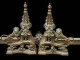a pair of ornately decorated brass candlesticks on a black background