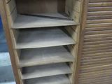 a wooden cabinet with a drawer and shelves on it