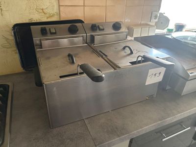 two deep fryers sitting on a counter in a kitchen