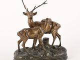 sculpture en bronze représentant deux cerfs sur un rocher, sur fond blanc