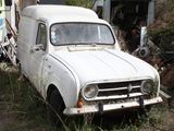 an old white truck that is parked in the grass