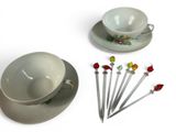 a tea cup and saucer with a spoon and spoon rest on a plate