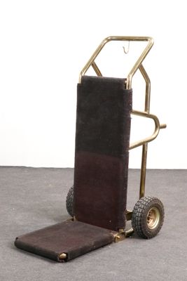 a small hand truck with a luggage bag on it
