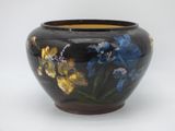 a black vase with blue and yellow flowers painted on it