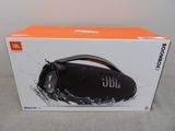 La boîte de la Boombox JBL est ouverte sur la table.