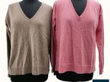 two women ' s v - neck sweaters on a mannequin stand