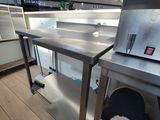 une photo d'une cuisine professionnelle équipée de plans de travail et d'appareils électroménagers en acier inoxydable
