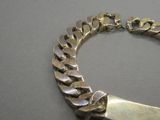 un bracelet en argent muni d'un fermoir en métal, posé sur une table