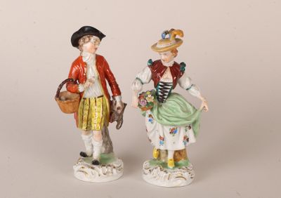 paire de figurines représentant un homme et une femme tenant des paniers de fleurs