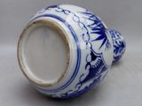 a blue and white vase sitting on a white surface