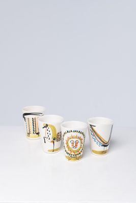 three cups with different designs on them sitting on a table