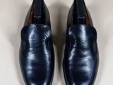 navy blue leather loafers with leather soles on a white surface