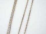 three silver chains are shown on a white surface