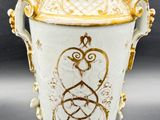 a white and gold vase sitting on a table