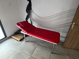 a woman standing next to a red bench in a room