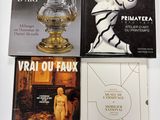 trois livres posés sur une table blanche, sur laquelle se trouve un vase doré