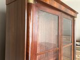 un meuble en bois avec des portes en verre dans une pièce