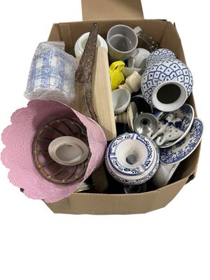 a cardboard box filled with assorted items on a white surface
