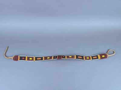 un bracelet composé de perles rouges et jaunes sur fond blanc