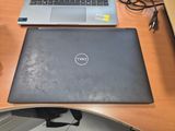 a dell laptop sitting on a desk next to a cup of coffee