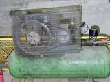 un compresseur d'air vert posé sur une table dans une pièce